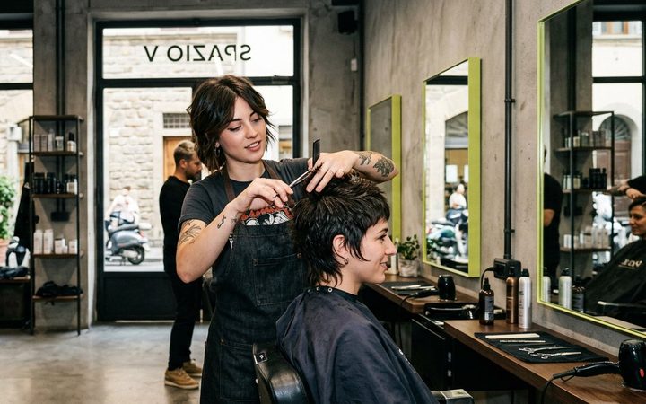 Demo Hair Salon: una stylist al lavoro in un salone moderno con pareti in mattoni